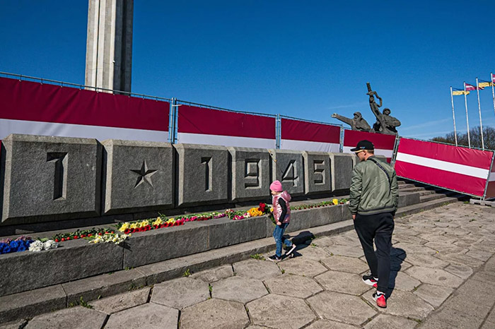 Жители Риги вновь несут цветы к памятнику Освободителям, откуда их сгребли трактором и вывезли на свалку
