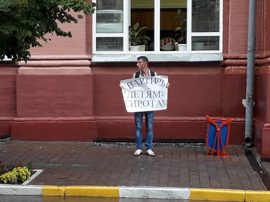 Фото дня. Ливень не помешал борцу за права сирот пикетировать администрацию губернатора