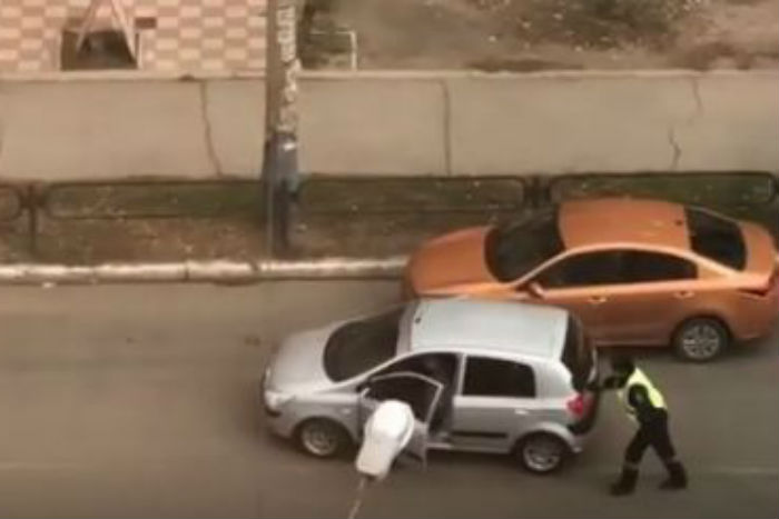 Одной правой: астраханский полицейский толкает машину легким касанием, видео