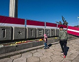 Жители Риги вновь несут цветы к памятнику Освободителям, откуда их сгребли трактором и вывезли на свалку