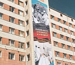 Баннер с изображением медиков двух веков украсил фасад Александровской больницы