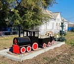 Миниатюрный паровоз с двумя грузовыми вагонами установлен на станции Кутум Астраханского региона ПривЖД 